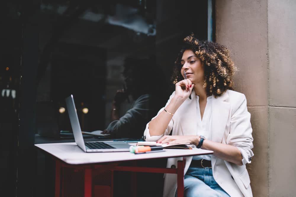 Beautiful African American female wearing cute dressy clothes while surfing the internet in an upscale cafe.