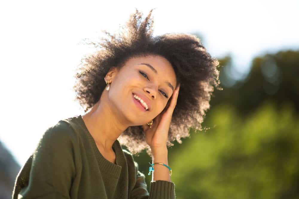 Young American female standing outdoors smiling on a sunny day.