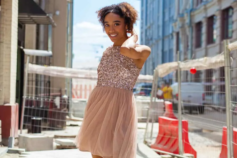 Cute black girl with a big smile wearing a pink dress.