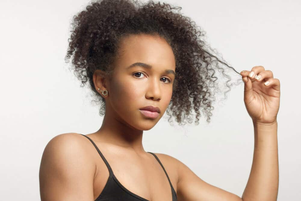 Young black woman showing off her wavy hair after using sea spray on her type 3 thinning hair strands