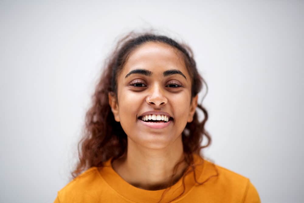 Cute American female smiling while wearing a nose ring and a braclet on her arm