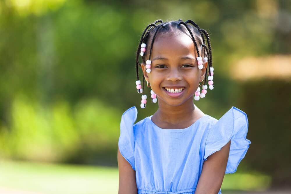 Learn how to put beads in your hair like this little girl with pink and white hair beads.