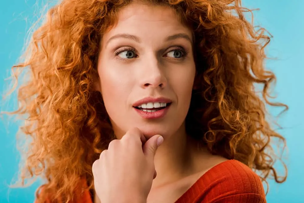 Caucasian adult female with mc1r gene as a natural red hair and light skin tone wearing a red shirt.