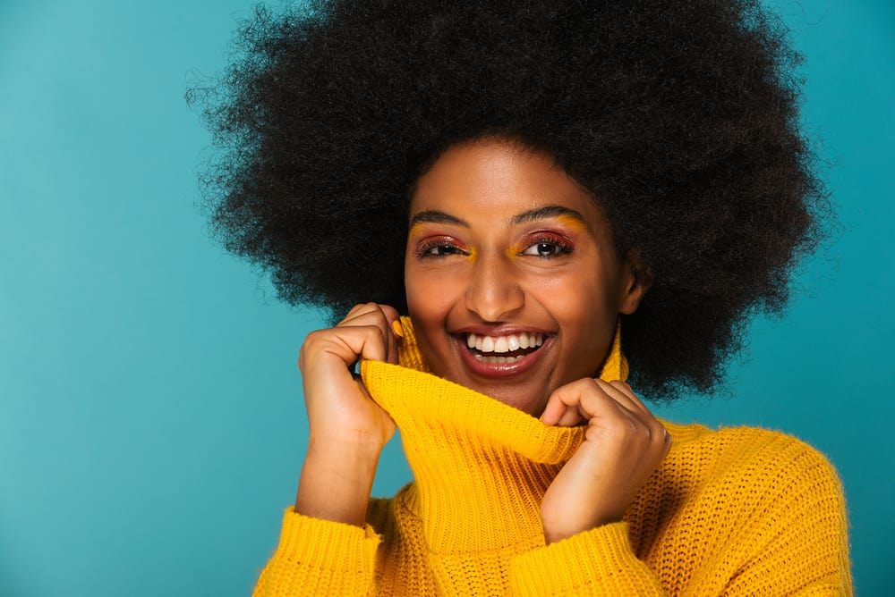 Cute black girl with 4c natural highlights wearing a yellow sweater