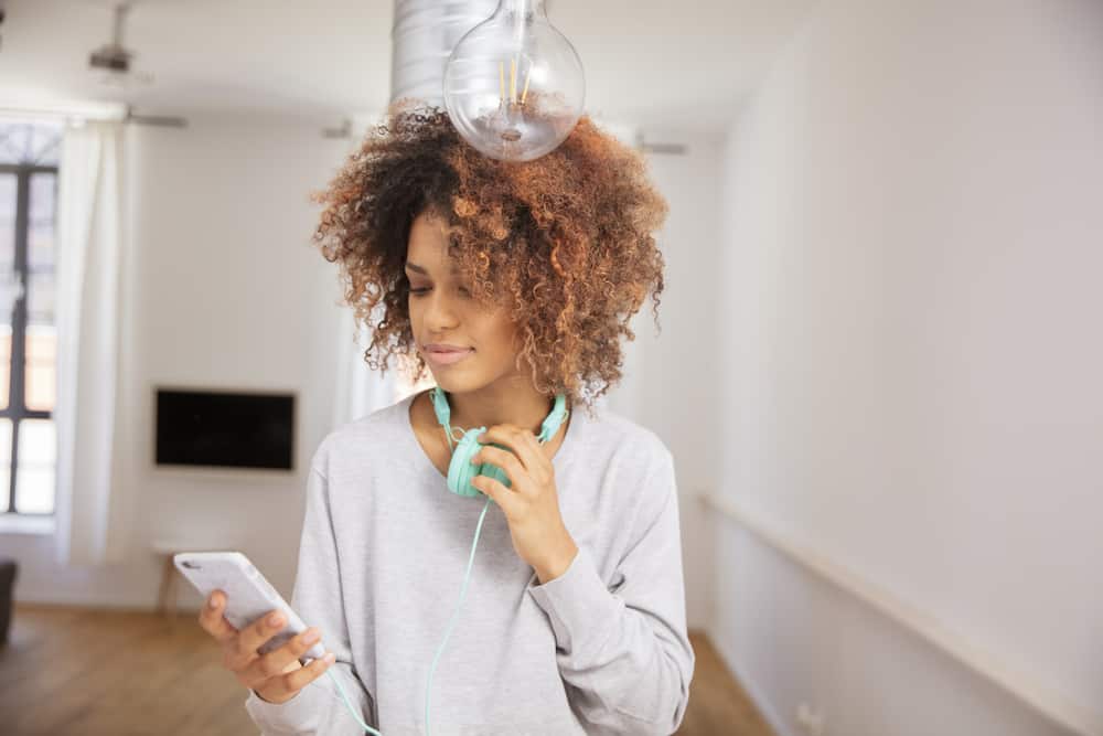 Cute female wearing a blue headphone type around the neck to avoid a band cushion issue leading hair dents