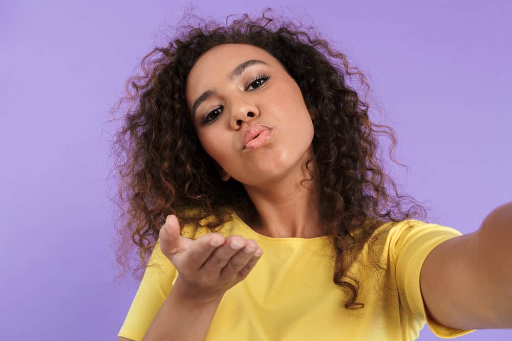 Young black girl blowing a kiss to the camera while taking a selfie