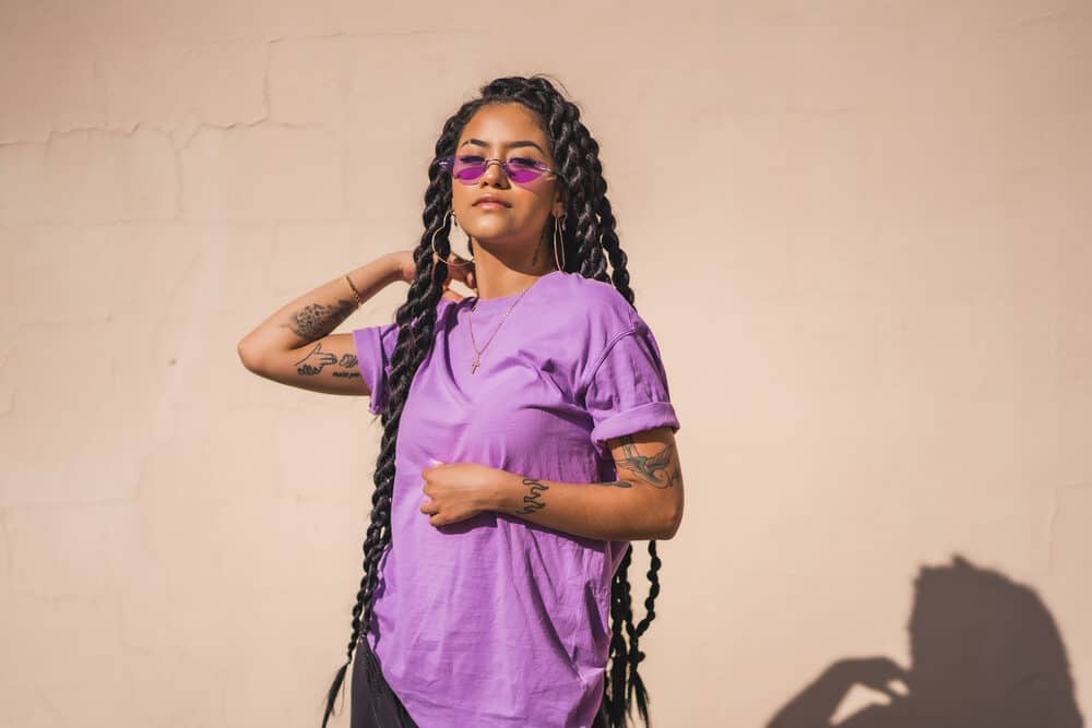 Cute black girl wearing a Brazilian human hair weft in braids with a purple shirt and sunglasses