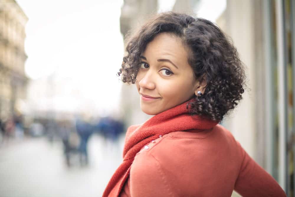 Cute black girl wearing a red sweater with short curly hair extensions