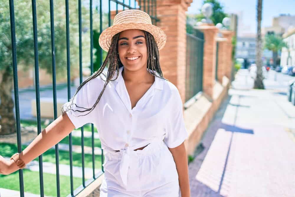 A young black woman is smiling and looking happy on a sunny day.