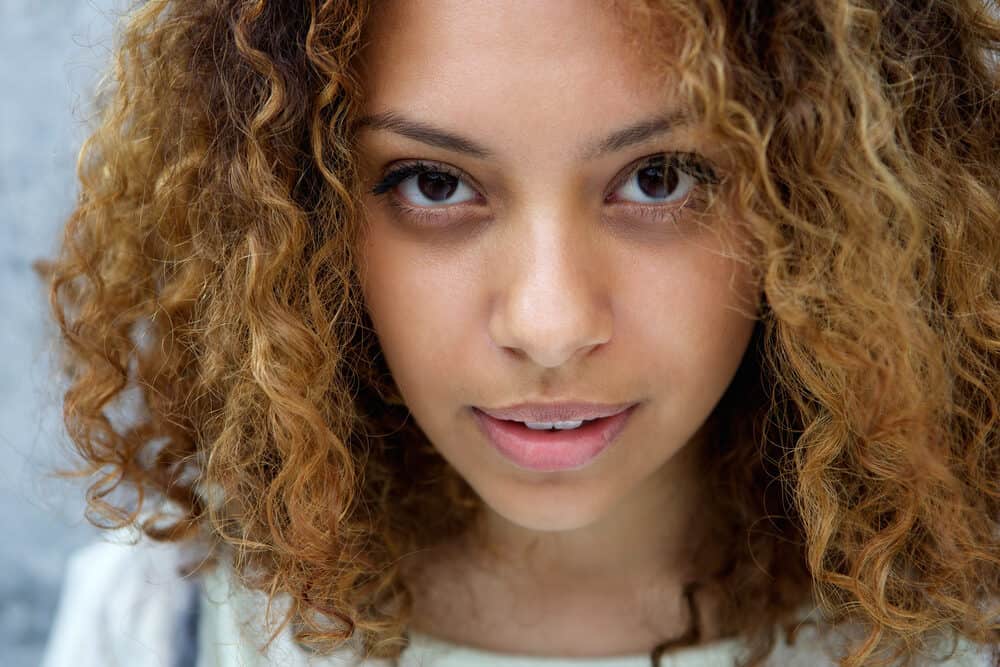 Close-up photo of a Latin female with light brown hair that's been lightened with bleach powder