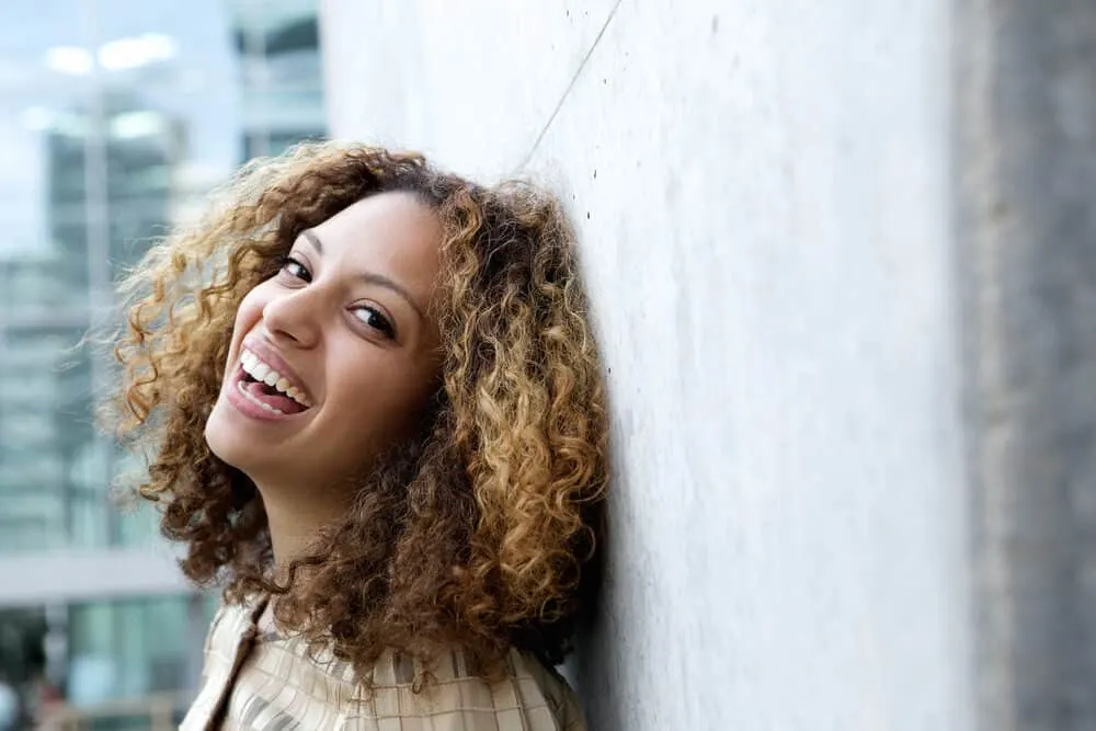 Light skin complexion mixed-race girl laughing while looking directly into the camera