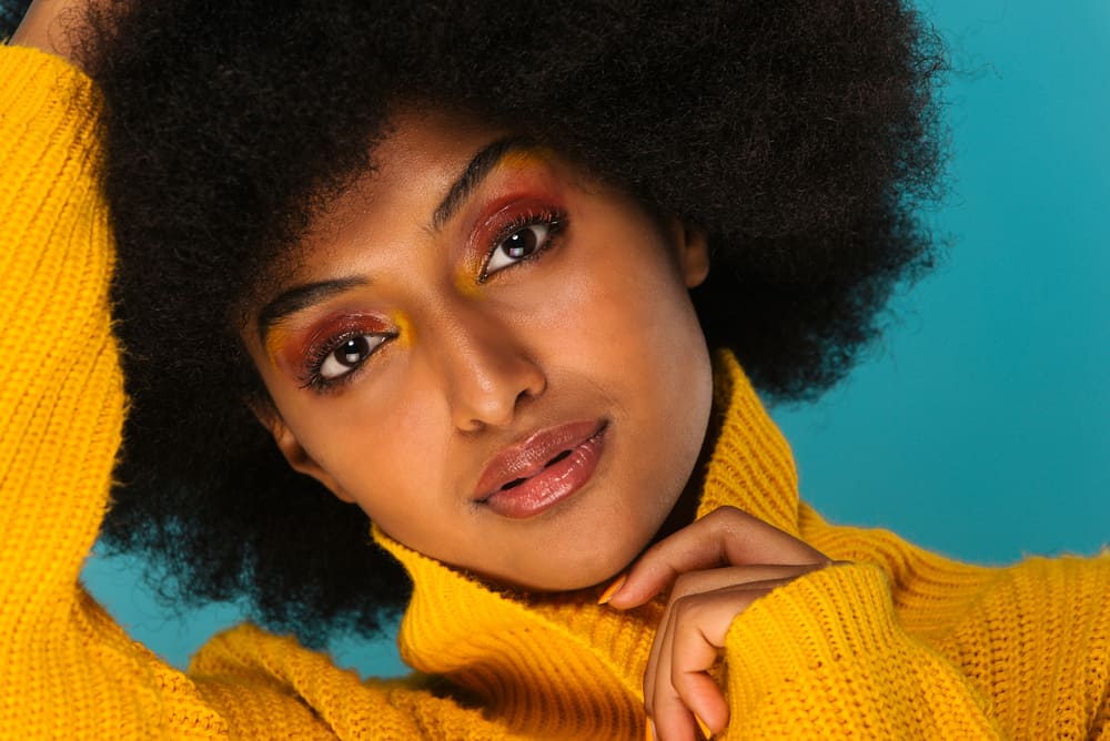 Pretty African American woman with towel-dried hair wearing dark red eye shadow and lipstick