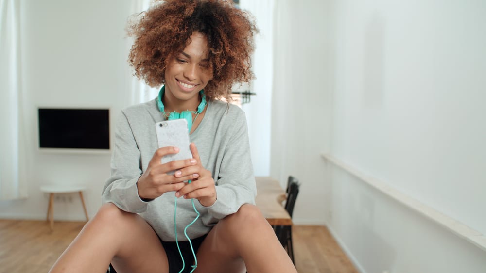 Cute female wearing a blue headphone type around the neck to avoid a band cushion issue leading hair dents