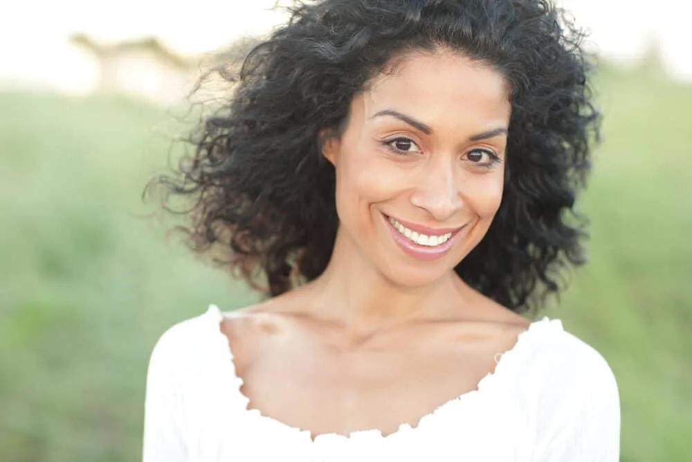 Cute African American women with long wavy hair wearing a white shirt