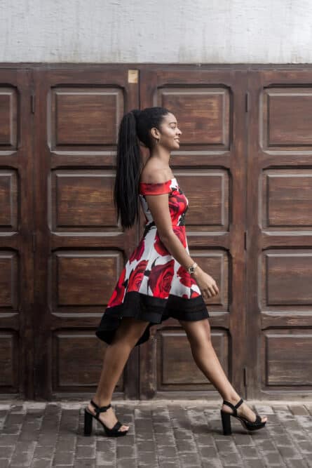 Black female walking home wearing high heels and ponytail weave on the back of her head.