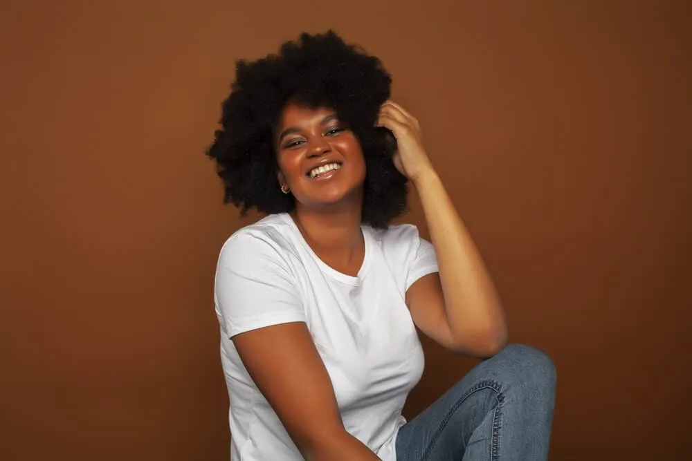 Can You Leave Conditioner in Your Hair Too Long? Overnight? 2 A cute black girl after leaving the beauty shop wearing natural curls and gold earrings.