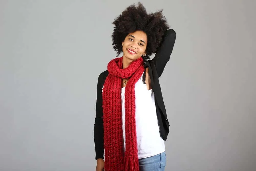 What is Coily Hair and How Do I Care for It? 12 A woman with natural hair in an afro hairstyle wearing casual clothes.