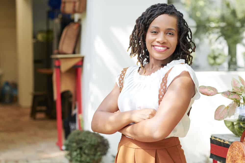 African American female with a black and brown curly dreadlocks hairstyle.