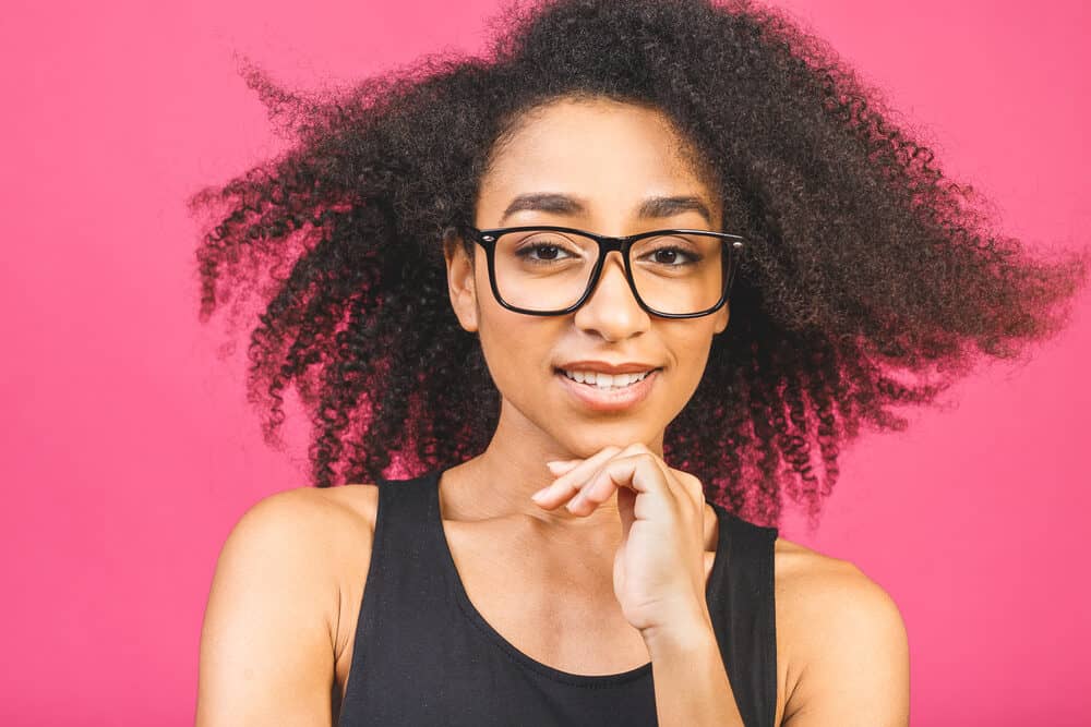 Cute picture of a female with thick wavy curls and dark eyeglasses.