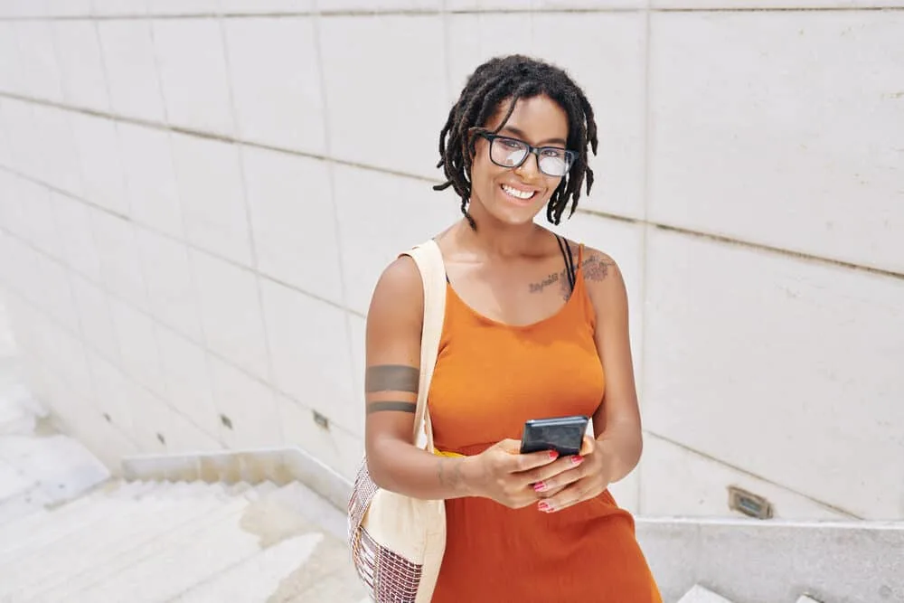 Dread Detox: How to Deep Cleanse Dreads with an ACV Rinse 1 A young African woman with a sophisticated dreadlocks hairstyle used a deep cleaning treatment to detox dreads.