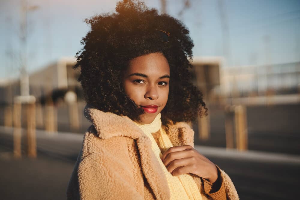 A young African American female with a type 4 hair type is showing off her own hair texture with a wash-n-go style.