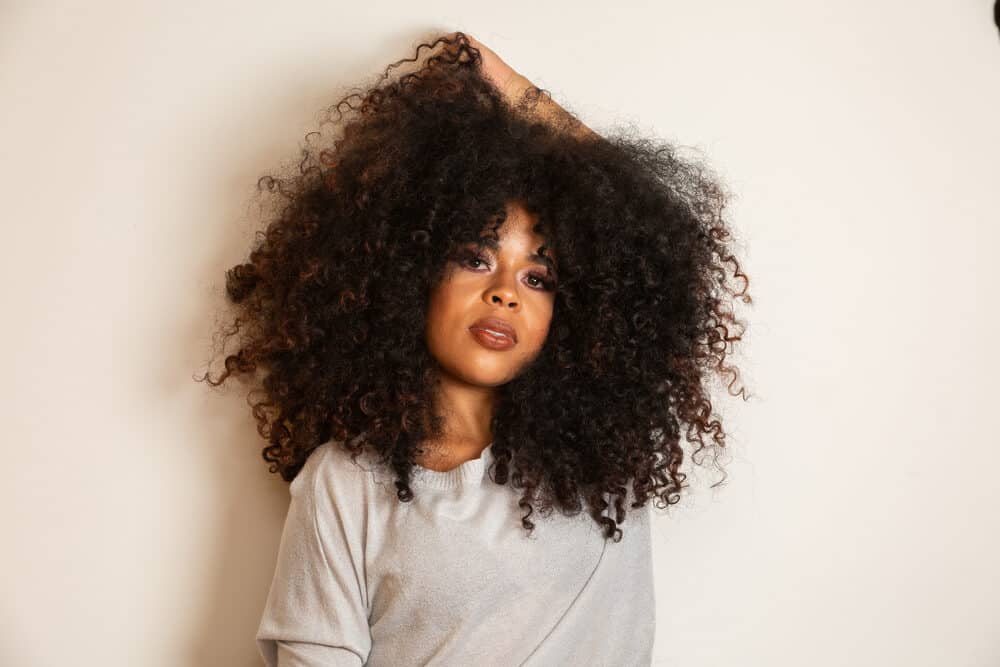 Women wearing brown, curly u tip hair extensions and a gray shirt