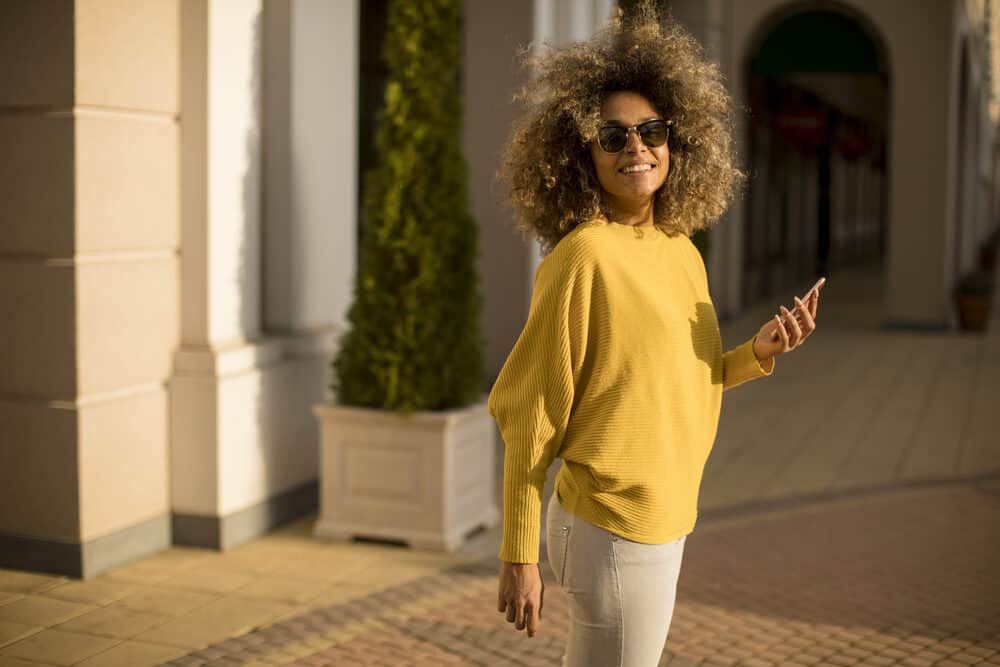 An attractive young woman with Hicolor hair color is on the street, talking on her mobile phone.