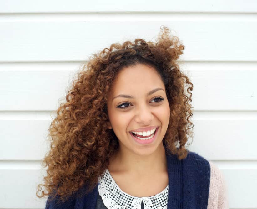 Women with naturally dark hair wearing a blonde hair look due to a partial balayage hair treatment.