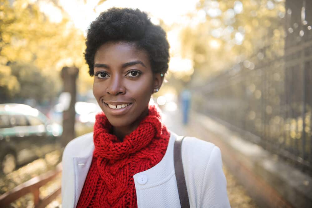 Cute black girl with short hair displaying soft z pattern curls moisturized with olive oil.