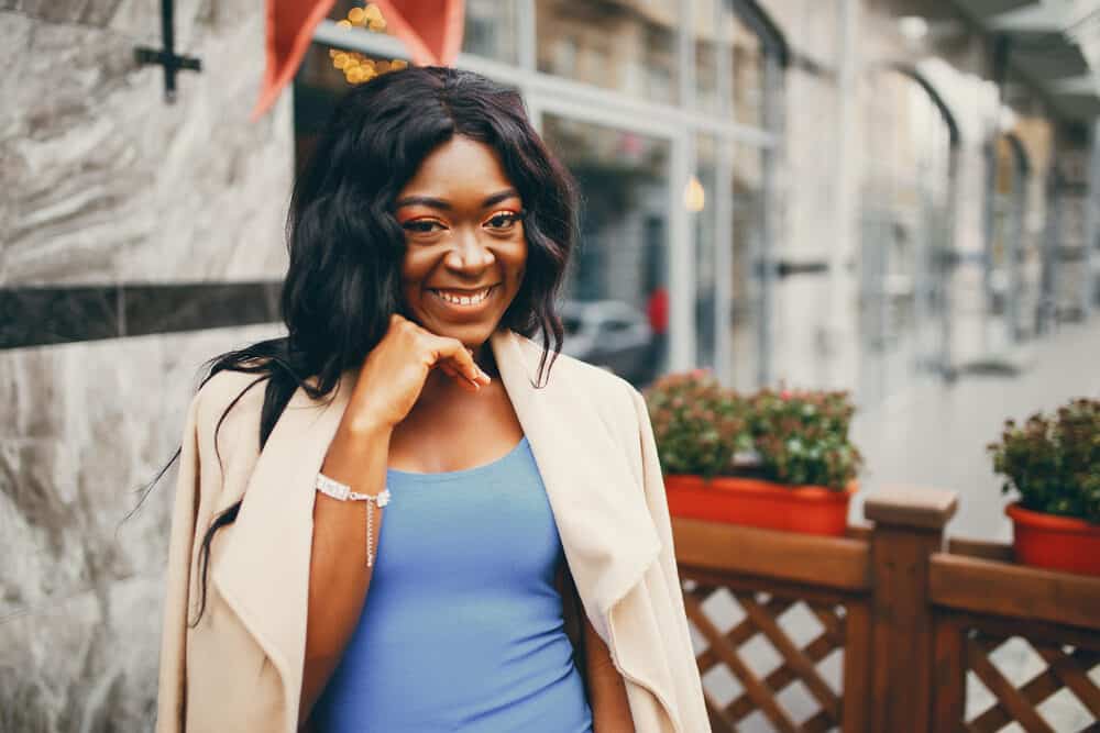 Black woman with type 4 straight weave standing outside of a cafe