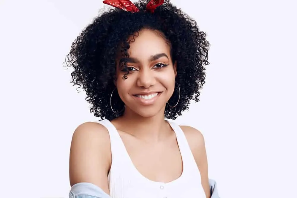 Are Hair Extensions Bad for Your Hair? How To Mitigate Damage 1 Cute black girl wearing semi-permanent hair extensions attached to her own hair.