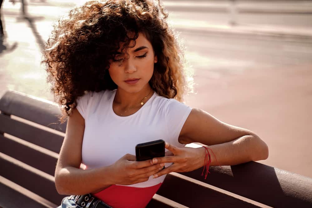 Colombian lady utilizzando iPhone 13, controllando Facebook, Twitter, e-mail e vari siti web leggendo gli ultimi articoli sul risciacquo con acqua dura.