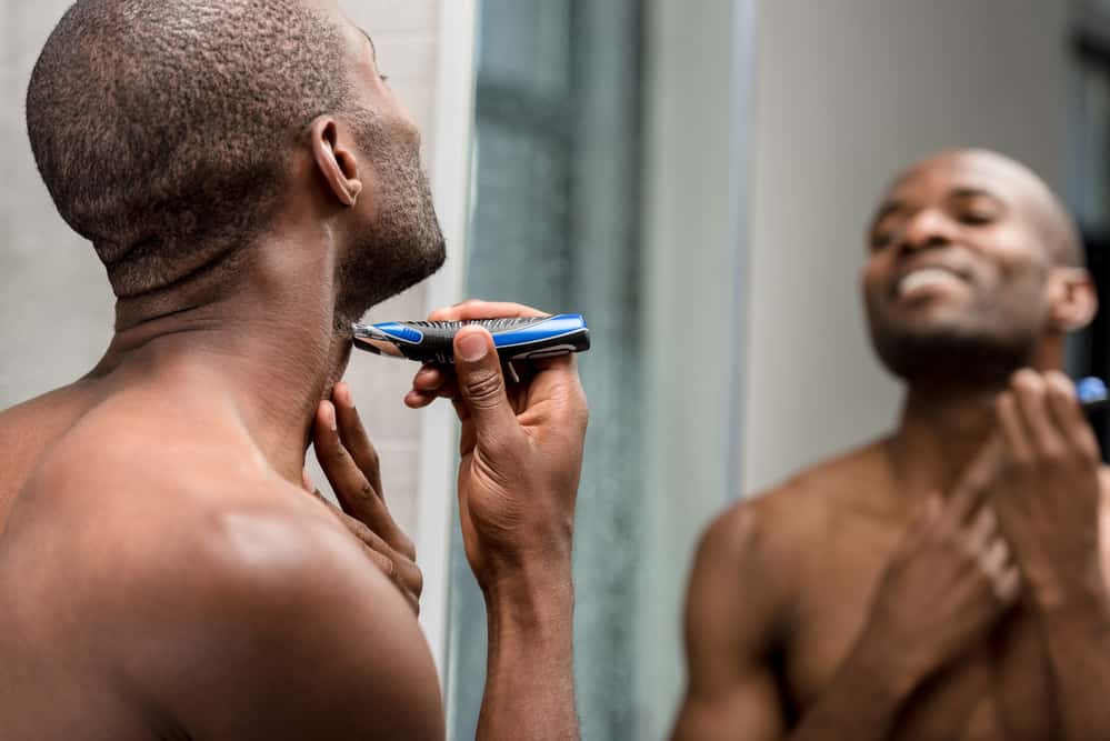 Guy shaving rough hair with clippers blades.