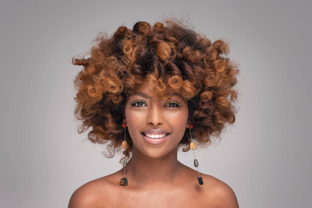 Black woman with a healthy head of hair wearing natural makeup and fashionable earrings