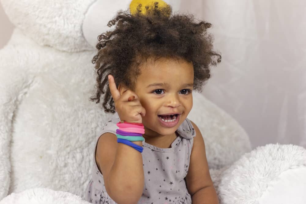 African American toddler with slime infested hair while coloring a picture