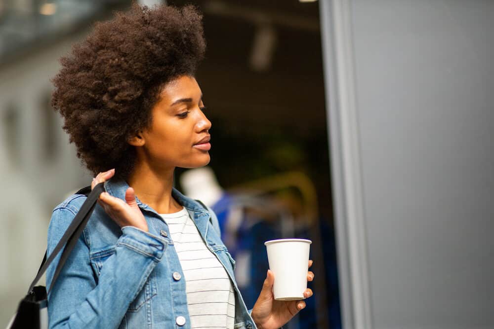 Cute girl drinking coffee and letting her soaking wet hair air dry outside.