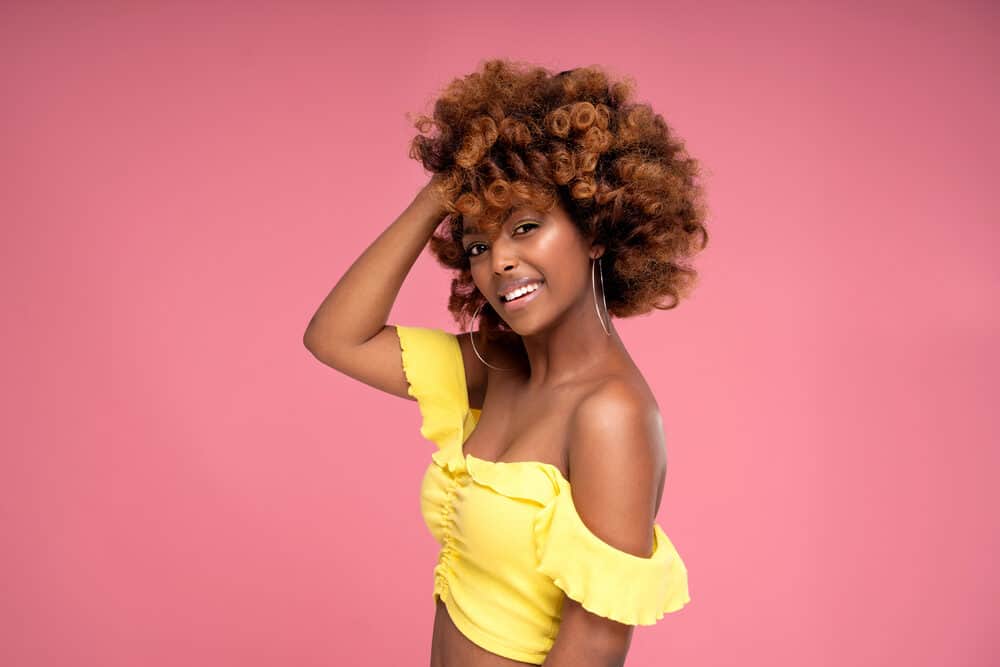 Cute black girl wearing a yellow shirt showing off her curl pattern after a deep conditioning treatment