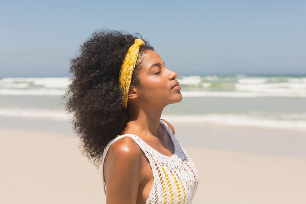 Cute African American lady with small frame body enjoying the fresh air at the beach