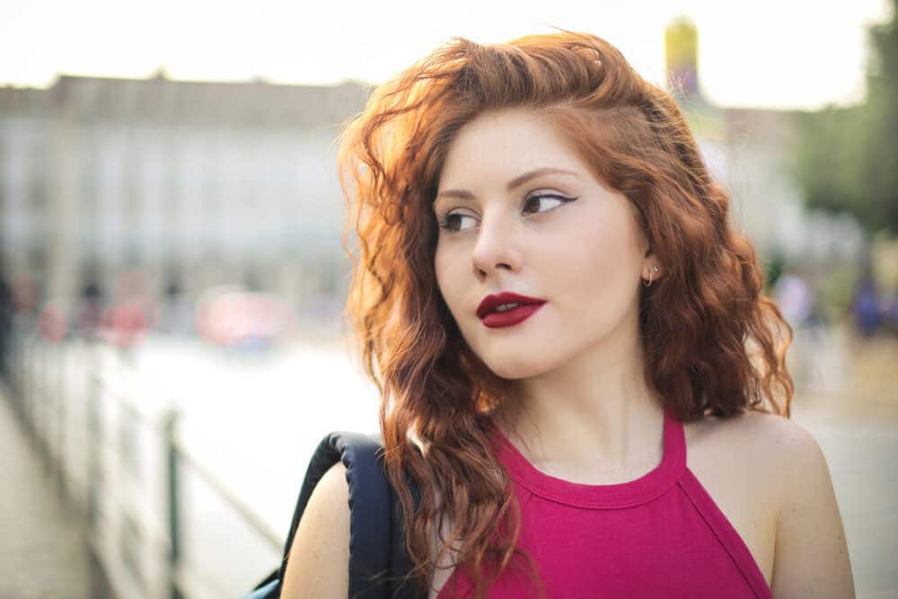 Young girl wearing medium perm hair with subtle highlights and red shirt.