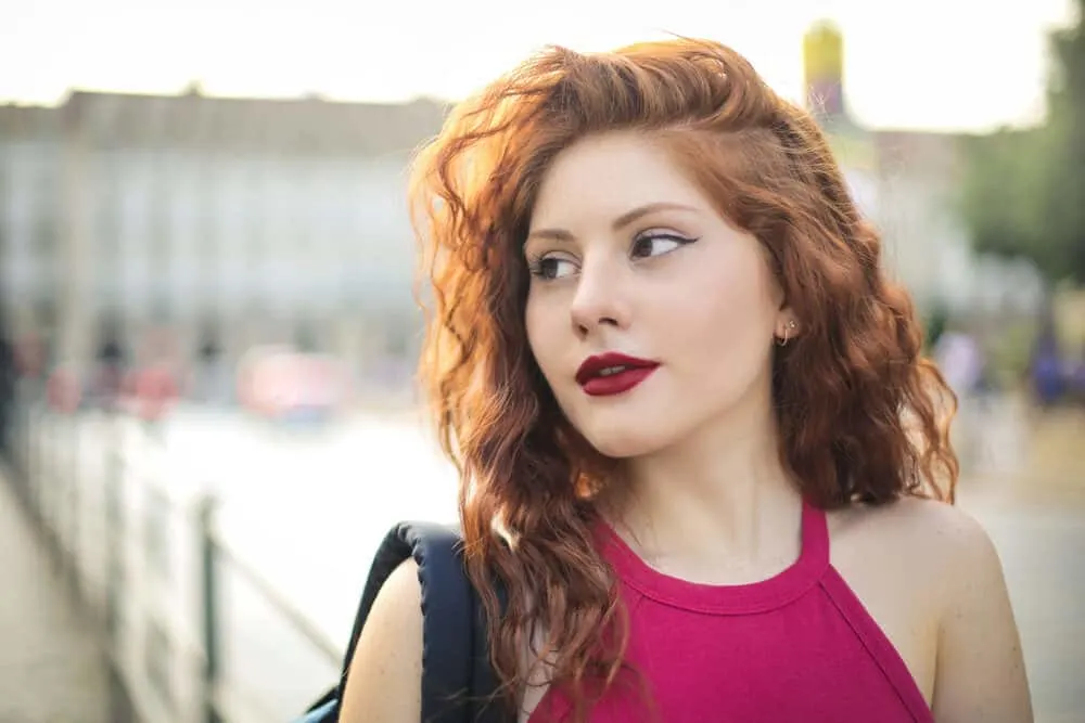 The Different Types of Perms for Thin Hair: Definitive Guide for Short, Medium, and Long Hair 1 Young girl wearing medium perm hair with subtle highlights and red shirt.