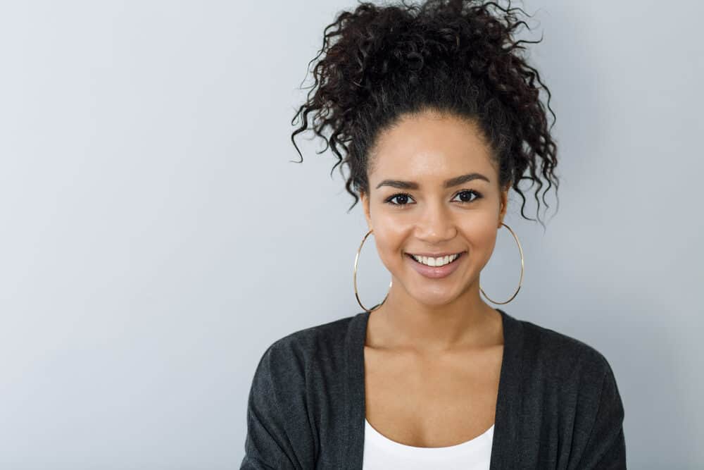 Black girl with hoop earrings wearing thick coarse hair treated with the wavy hair method