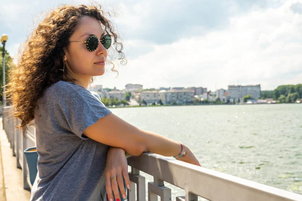 Beautiful girl on the pier of a salt water lake with sun-kissed highlights.