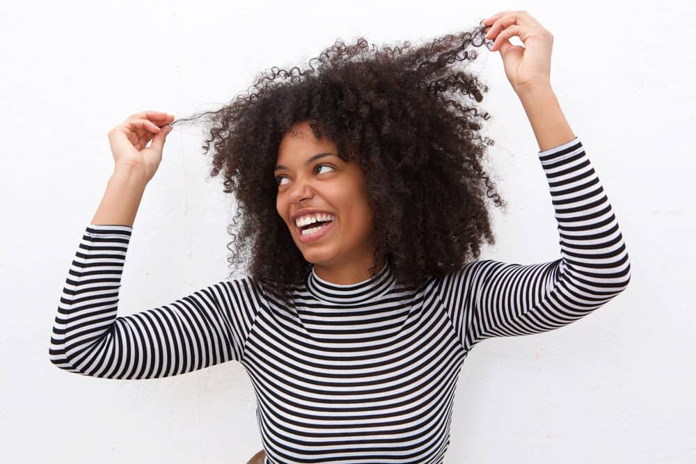 Black woman with a curly cut that highlights her type 3C and 4A curl patterns.