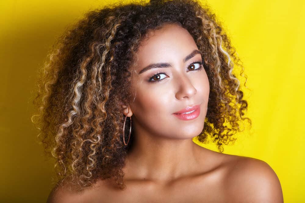 Young black girl with wavy hair curls preparing for her curly girl routine