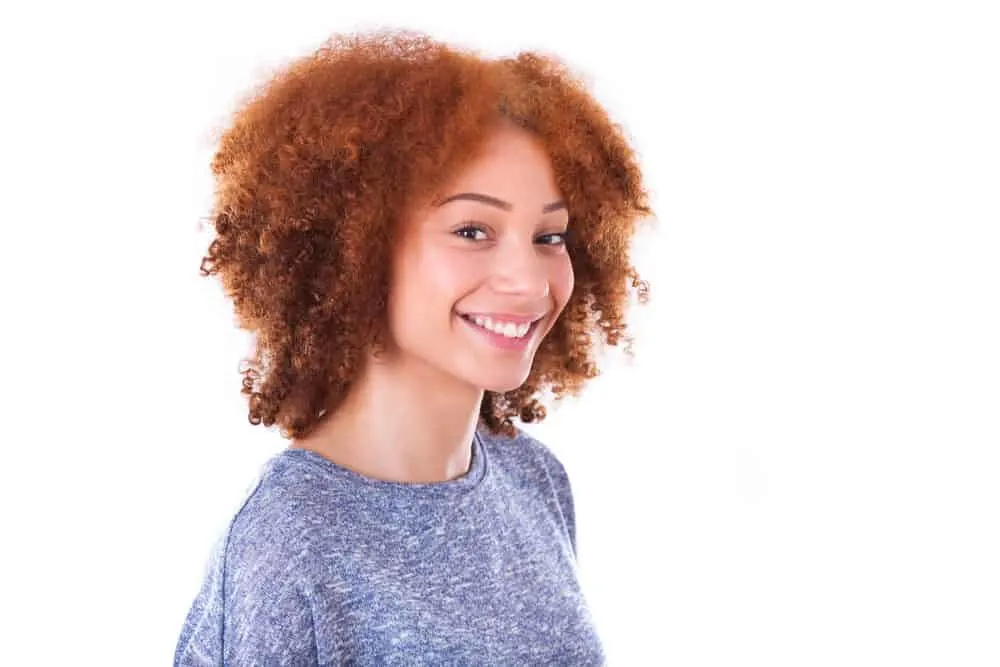 Can Black People Have Red Hair? Common Factors and Misconceptions 2 Black girl with light skin and dark brown hair wearing a blue sweater