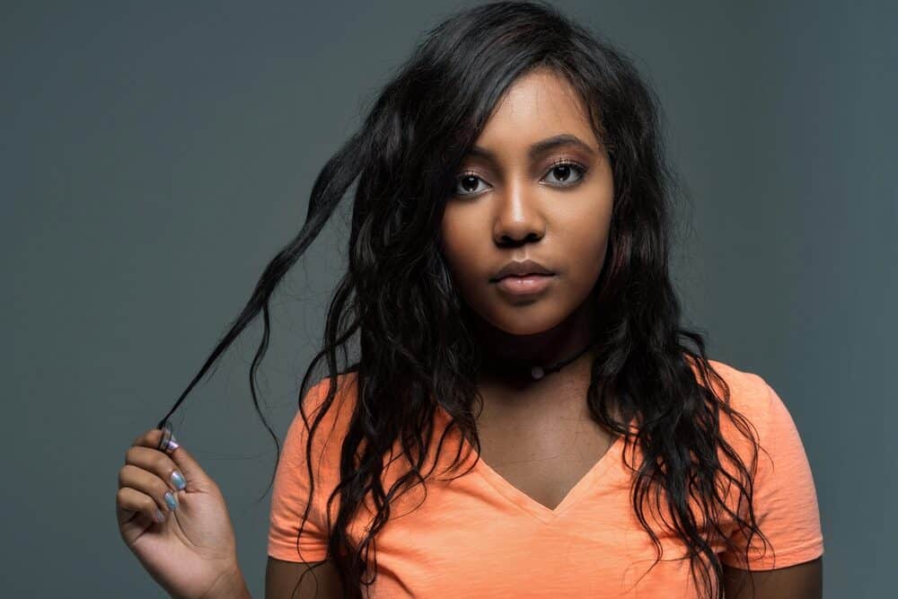 African American woman with a Dominican hair texture wearing an orange t-shirt