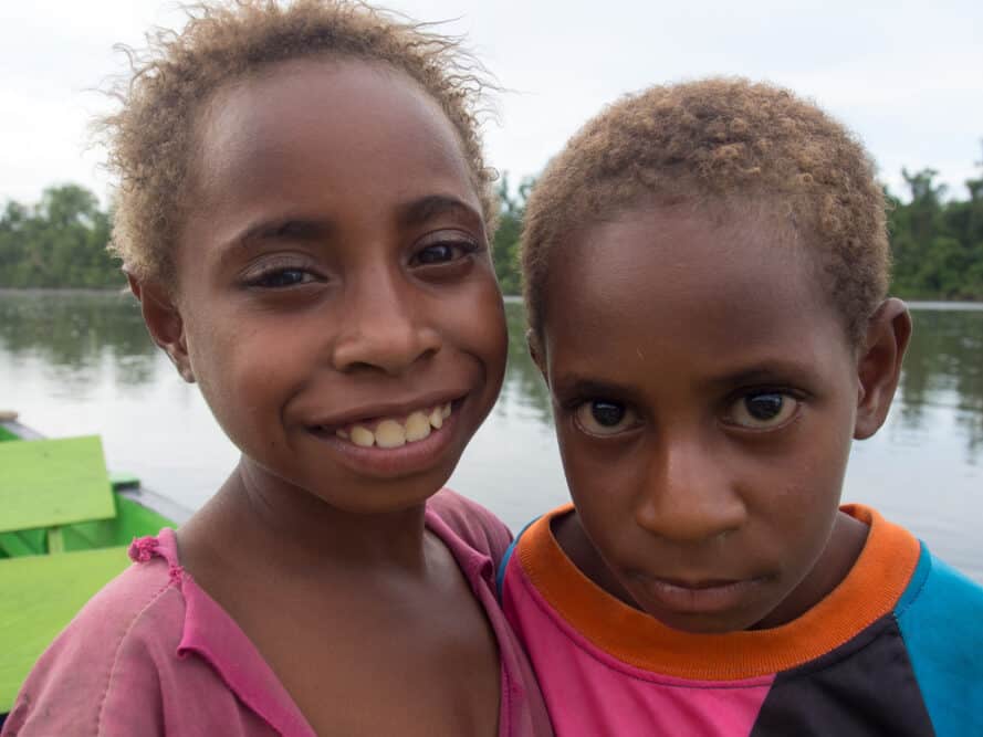 Two cute kids playing from the Korowaya tribe each carrying the mutant gene responsible for their blonde hair