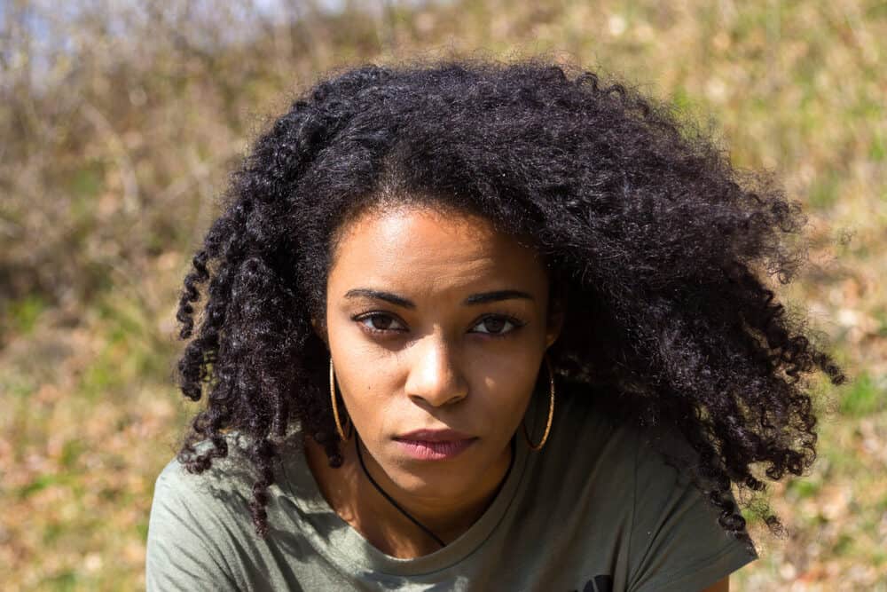 An attractive African American woman with afro hair cuticles wearing a green t-shirt