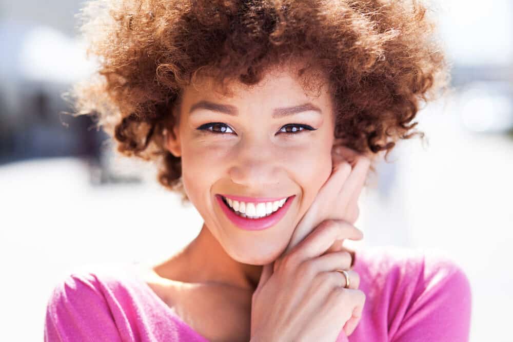 Cute black girl with purple dye on naturally curly dark brown hair