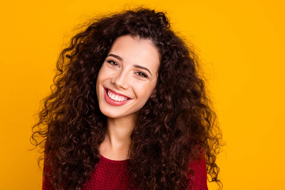 Attractive white woman with naturally curly hair wearing her loose curls with a red sweater
